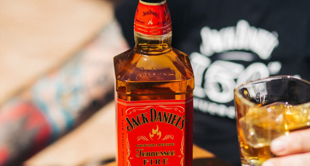 Detail lahve Jack Daniel’s Fire a sklenice s drinkem